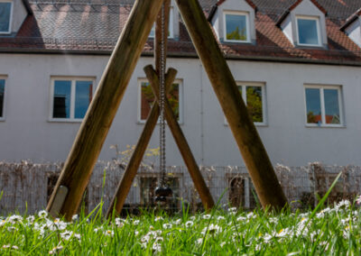 Schaukel auf grüner Wiese des InKiTa Kindergarten