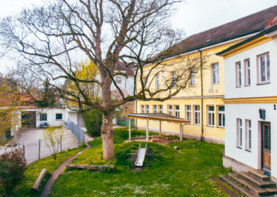 Garten mit Spielgeräten und grüner Wiese im Hinterhof