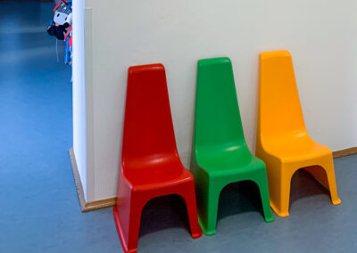 Vorraum mit drei Stühlen in rot, grün und gelb